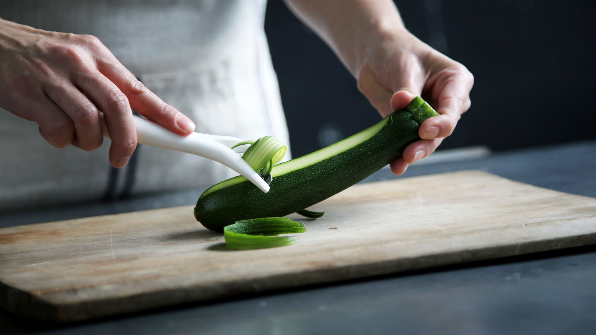 person peeling zucchini